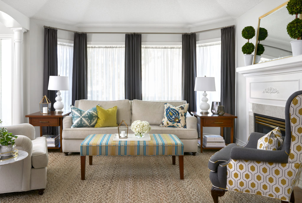 Oakville living room with dark grey drapery, neutral sofa, and colorful decorative pillows