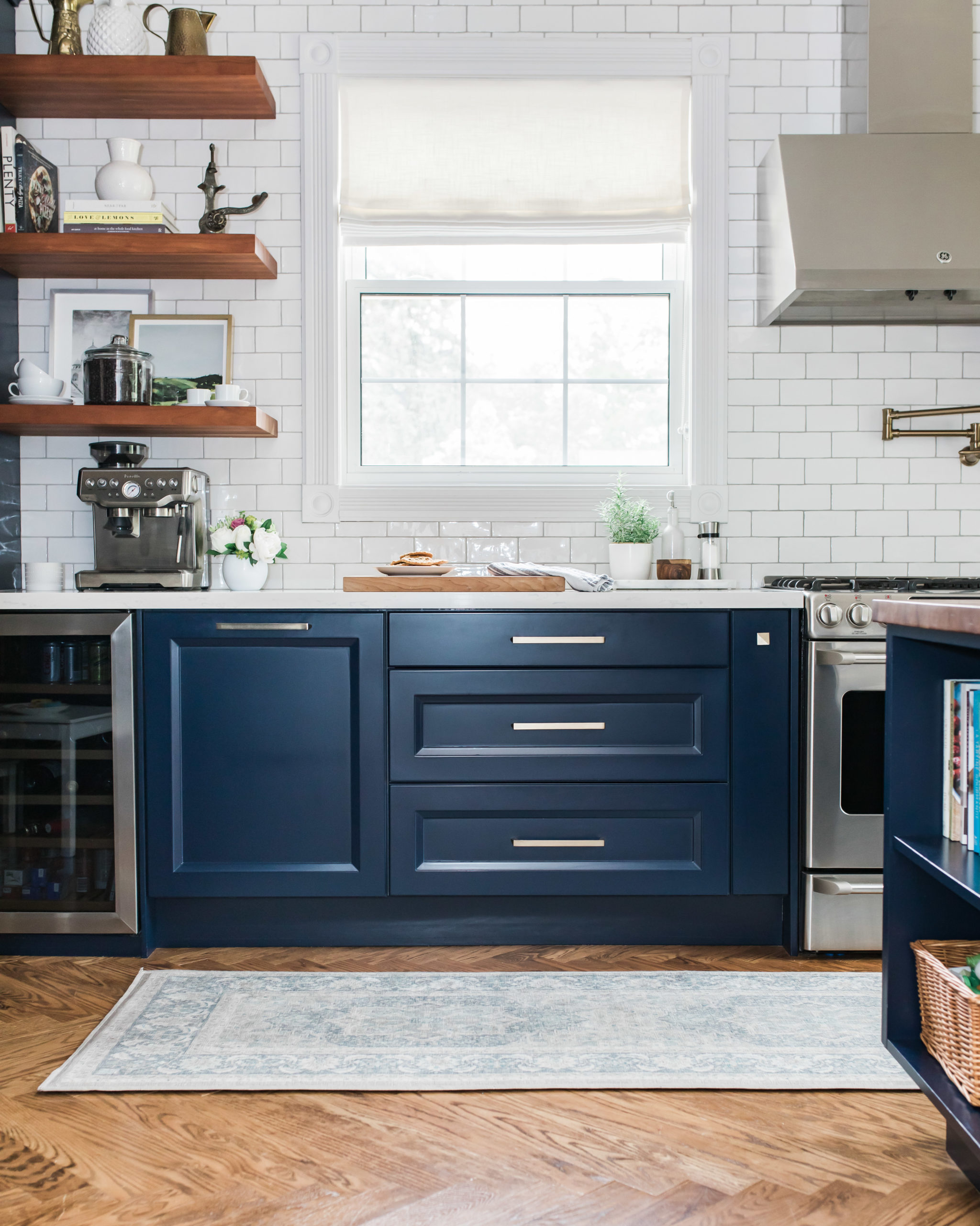 interior designer's kitchen with navy cabinets, gold hardware, and Persian inspired runner