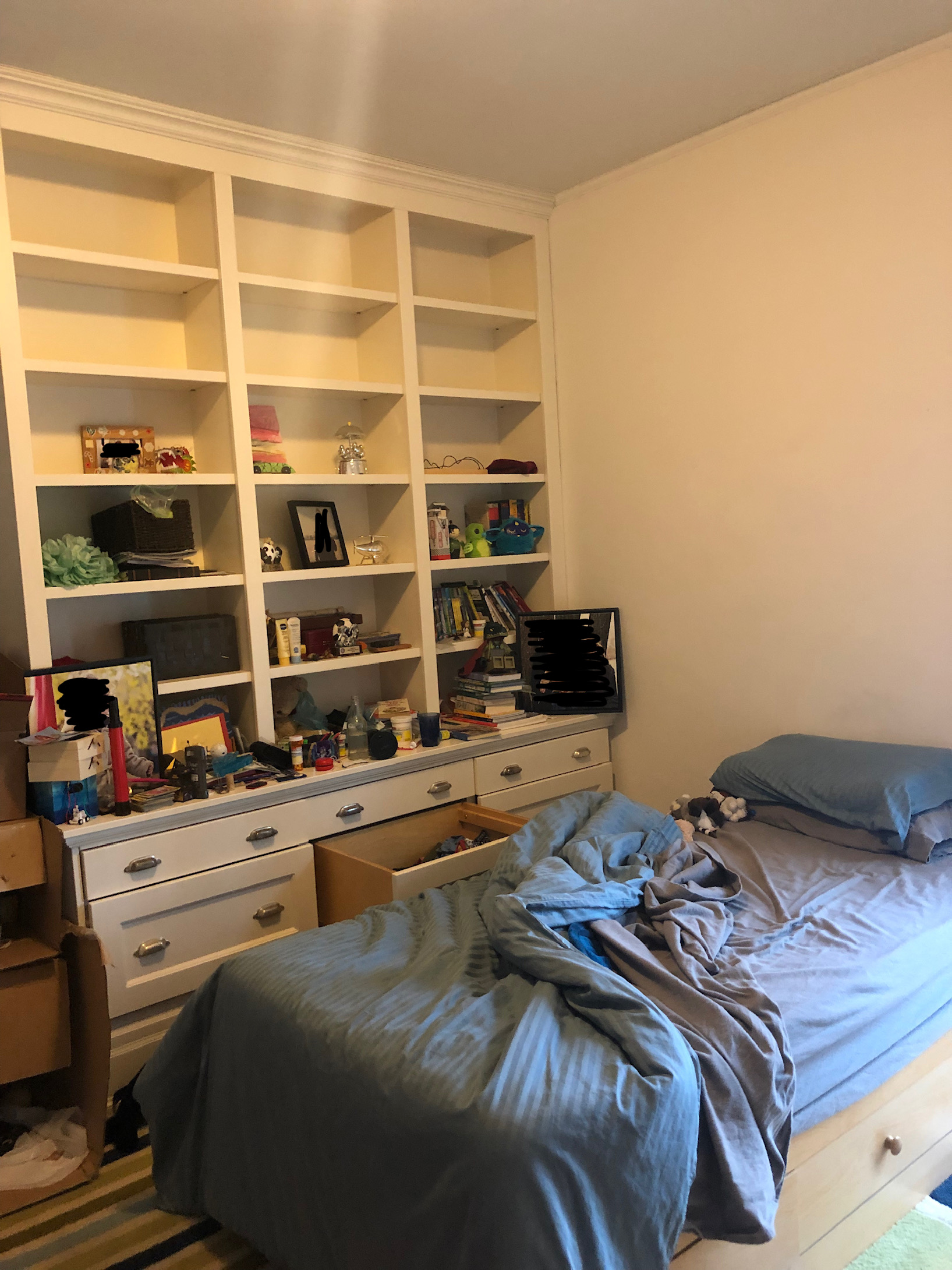 before photo of cluttered bedroom with open shelves and unmade bed
