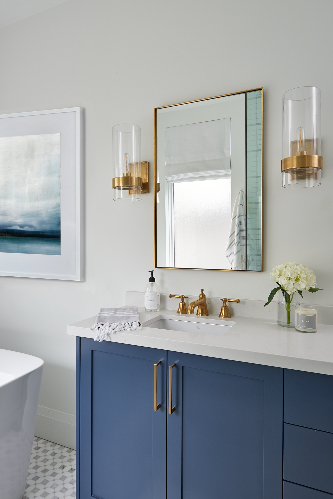 beautiful custom designed bathroom with blue vanity and gold fixtures