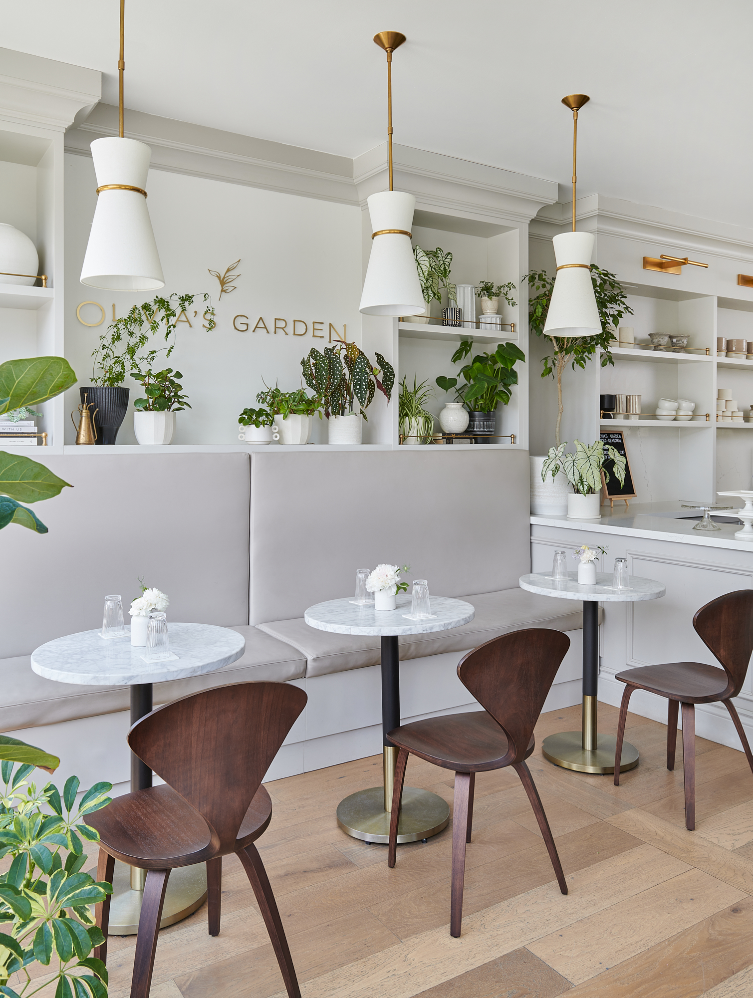 pretty coffee shop with banquette seat, round bistro tables, and modern wood chairs