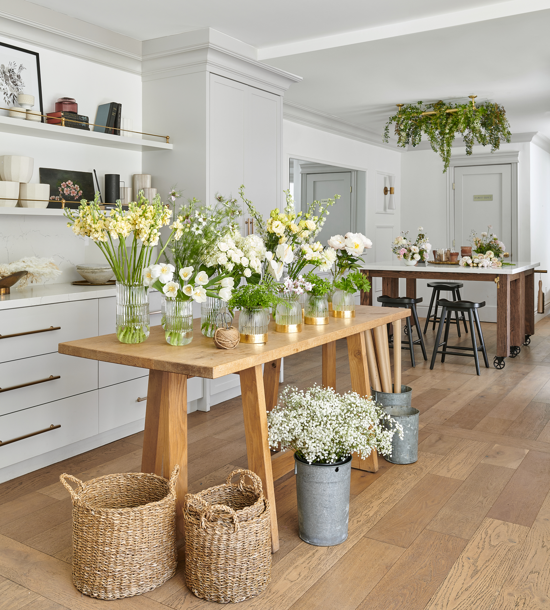 beautiful floral shop with wood table and lots of glass vases on top with flowers