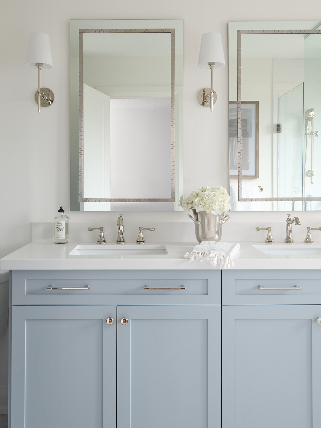 Soft blue custom vanity with mirrors wall sconces above