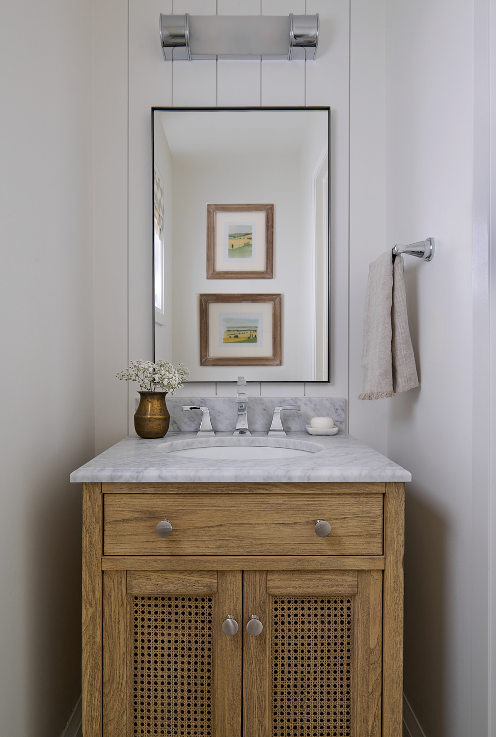 Small powder room with wood vanity and marble countertop