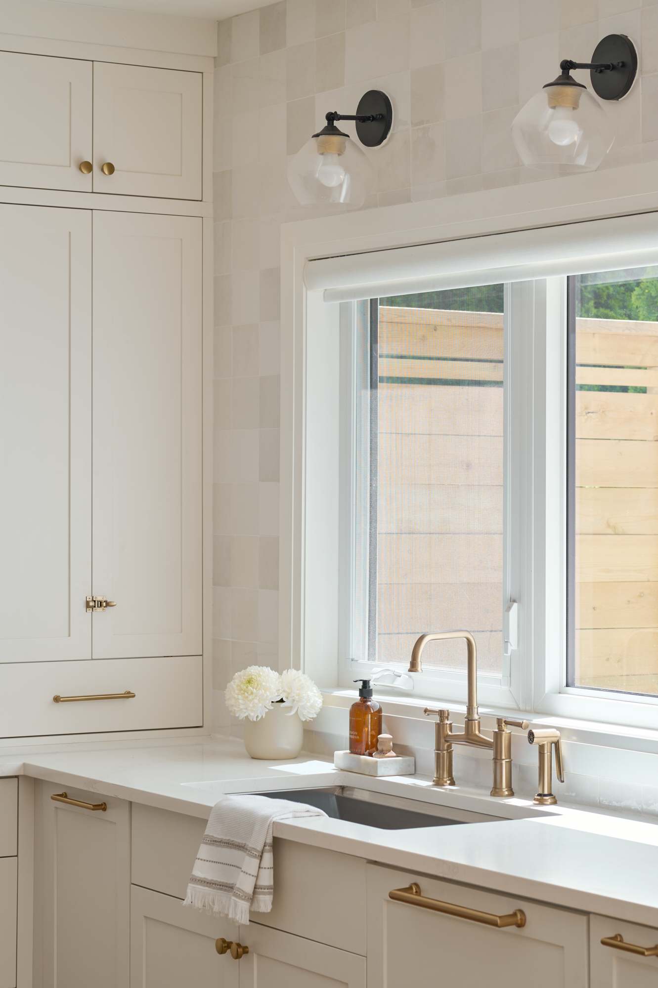 creamy white kitchen with zellige tile and gold hardware and faucet