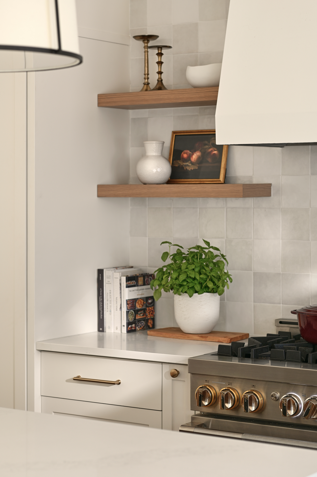 Corner of kitchen with open shelving beautifully styled with cookbooks, a plant, and accessories