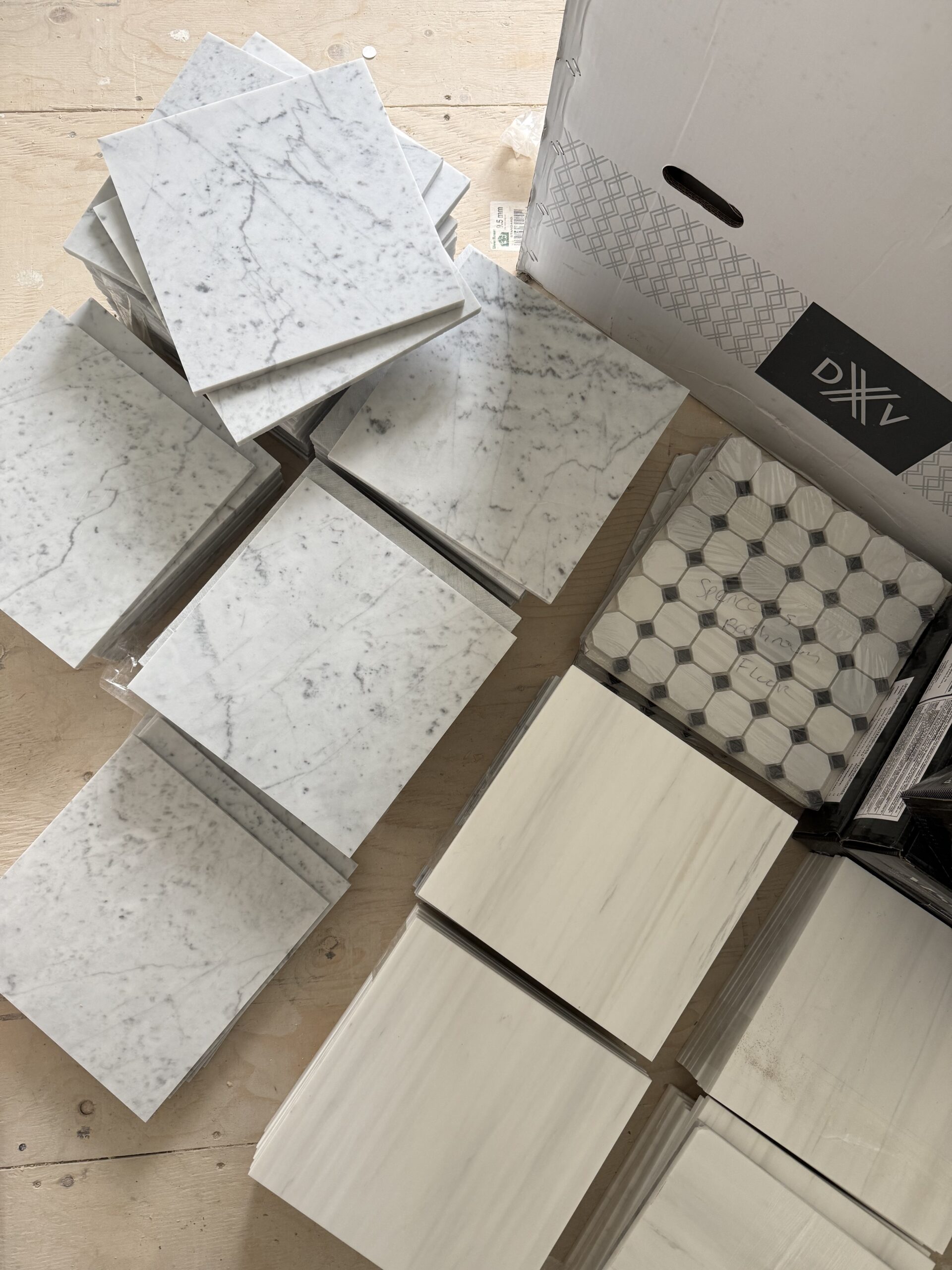 Assortment of marble tiles and decorative patterns selected for bathroom renovation