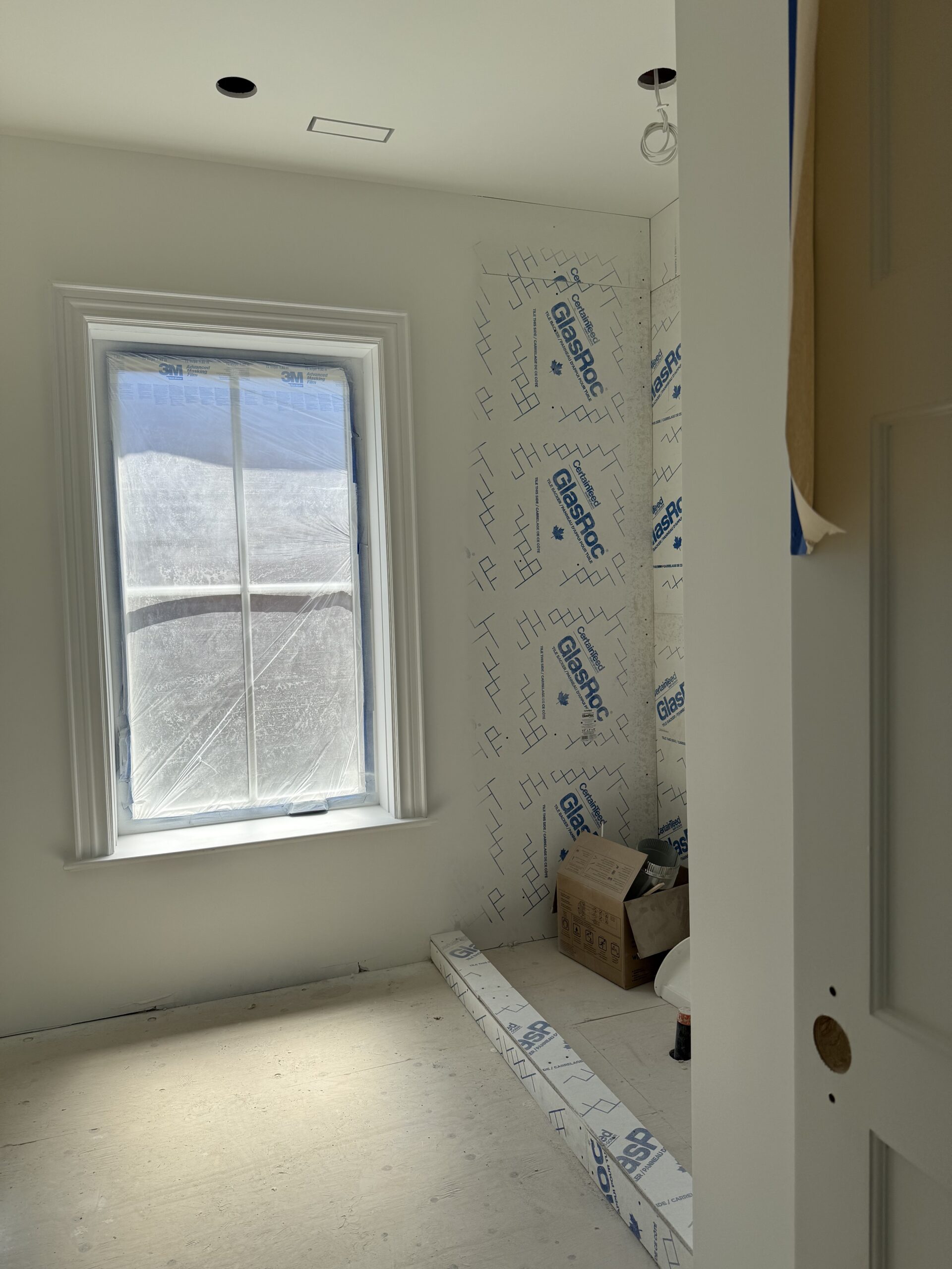 Ensuite shower area prepped with waterproof board and natural light from large window