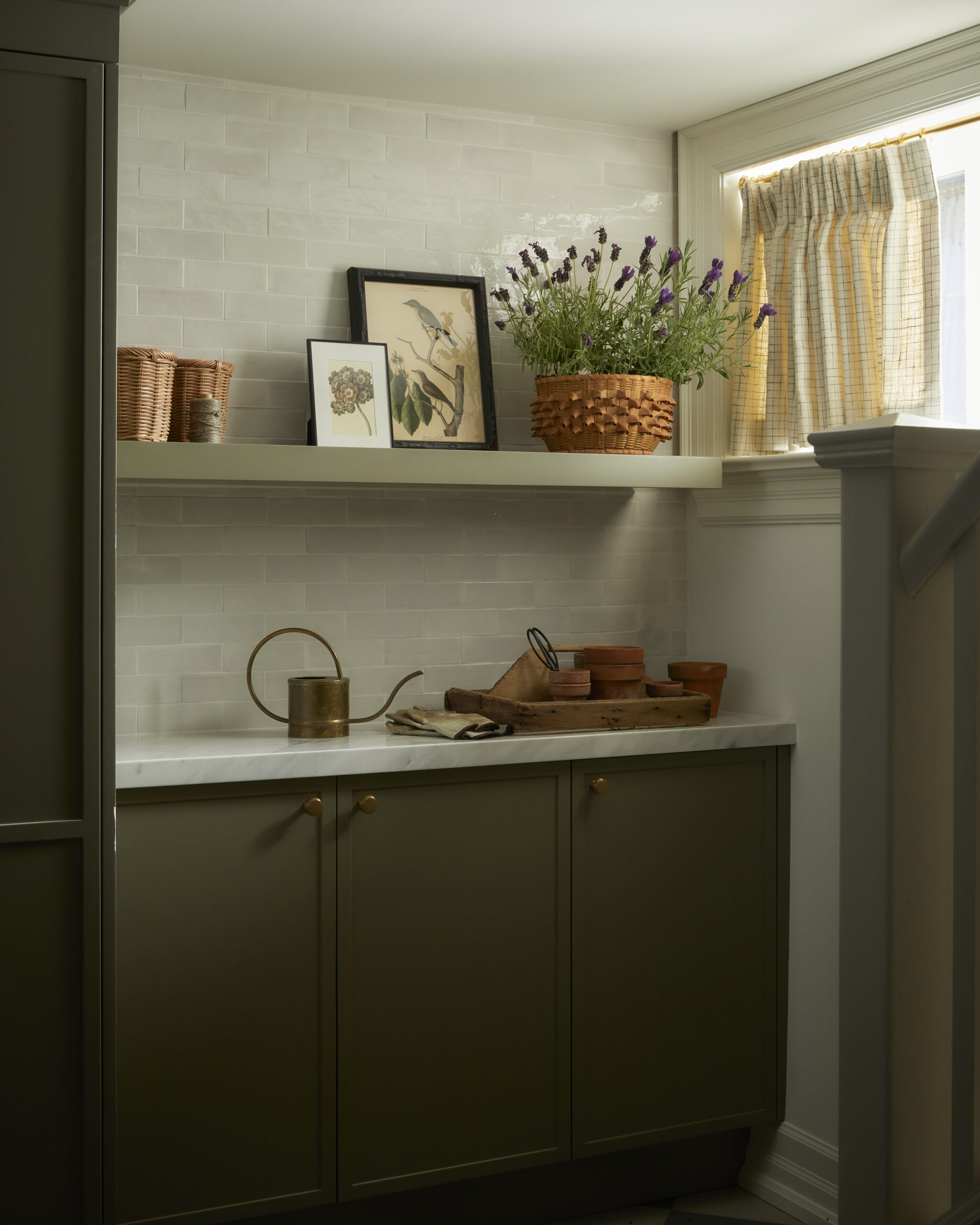 Beautiful and organized laundry room in renovated Rosedale Toronto home with green custom cabinetry