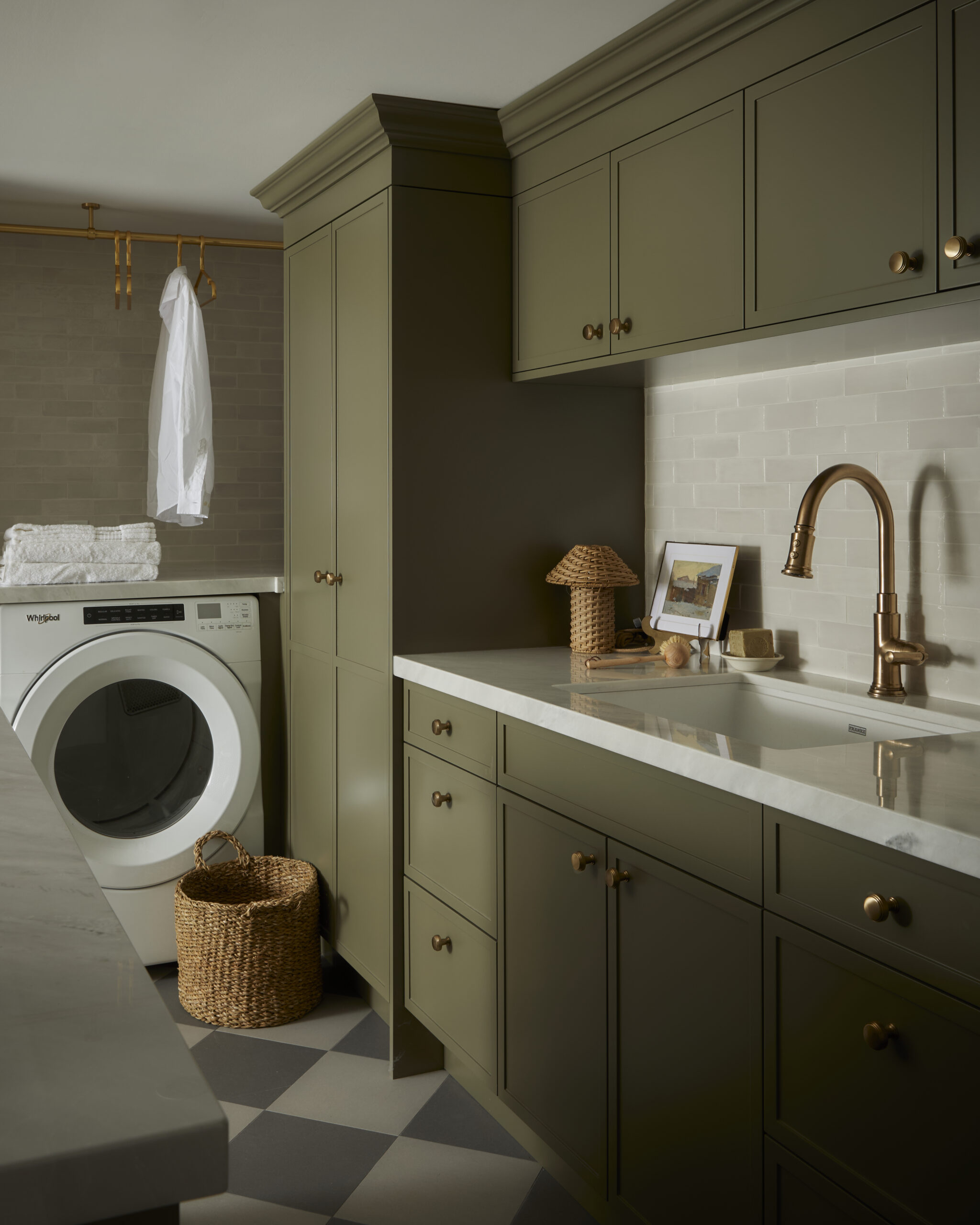 Beautiful and organized laundry room in renovated Rosedale Toronto home with green custom cabinetry