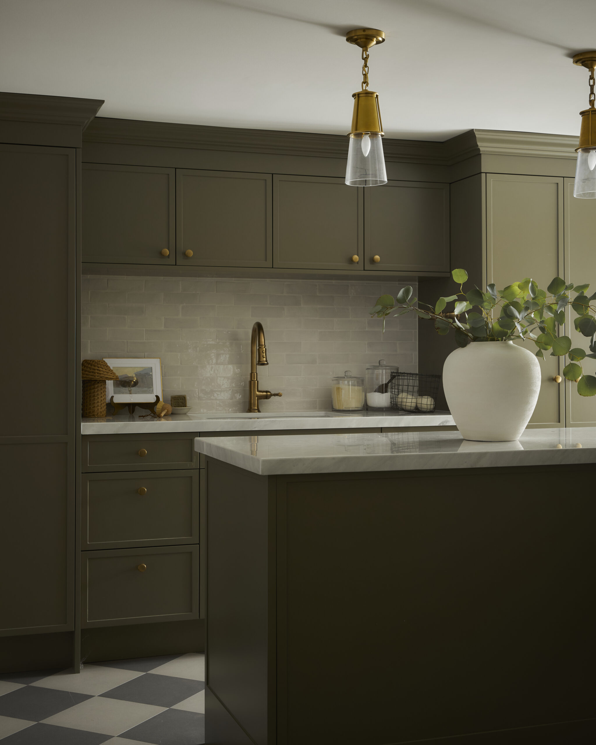 Beautiful and organized laundry room in renovated Rosedale Toronto home with green custom cabinetry