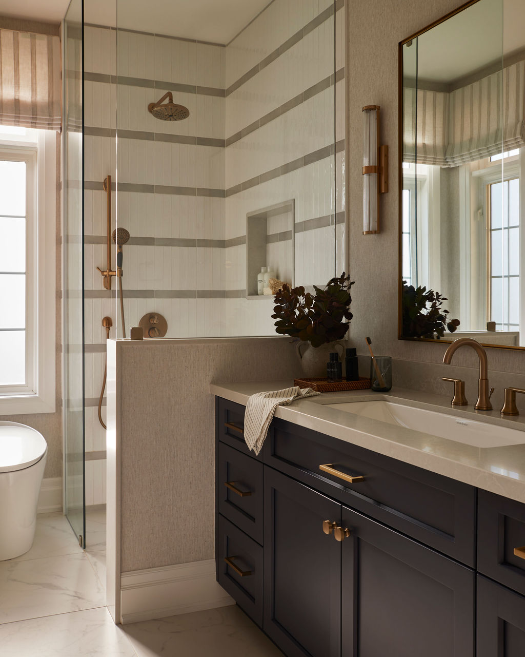 Kids bathroom with striped tile, navy vanity, and family-friendly design
