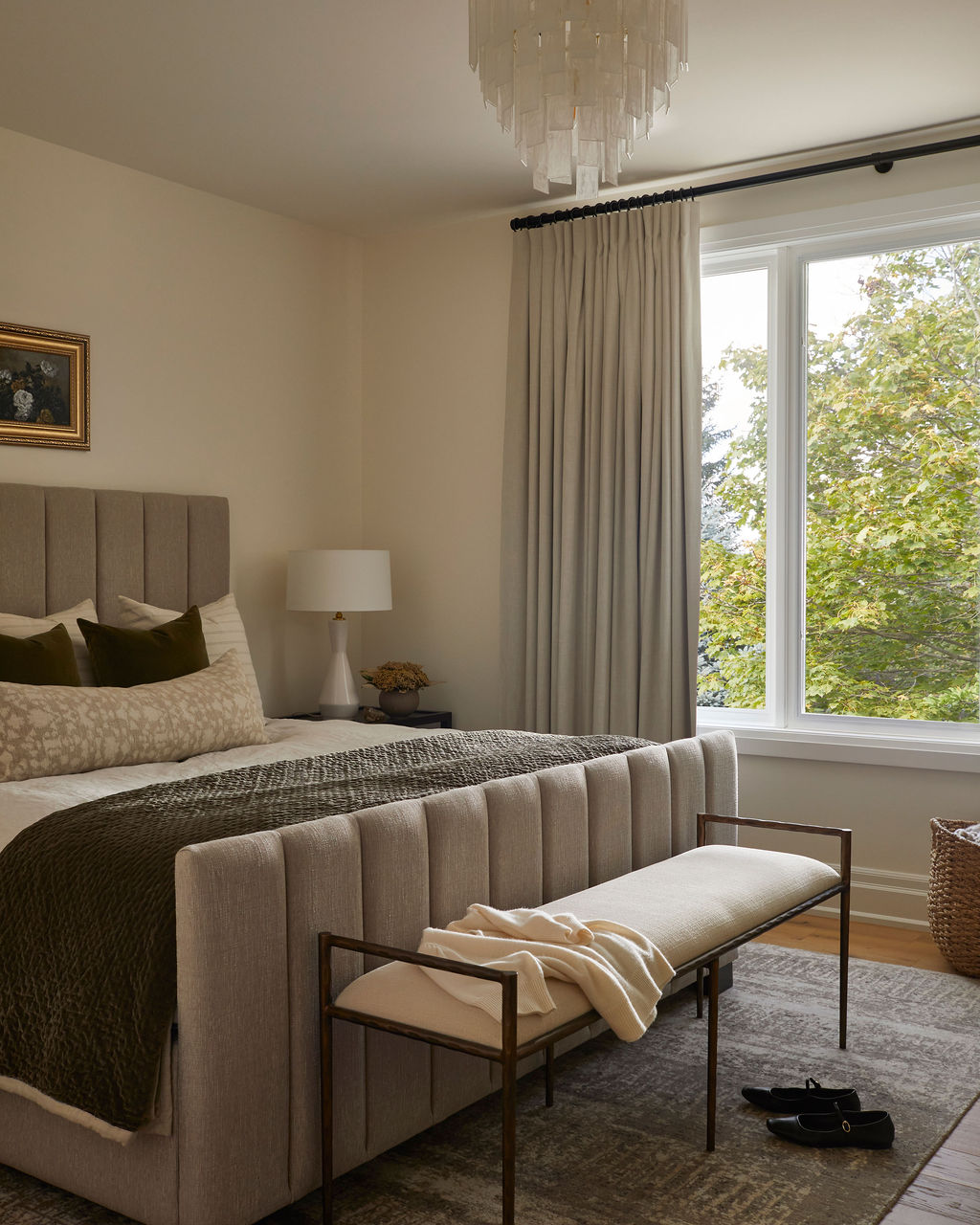 Serene principal bedroom with warm neutrals and a custom bench for a calm, elevated retreat