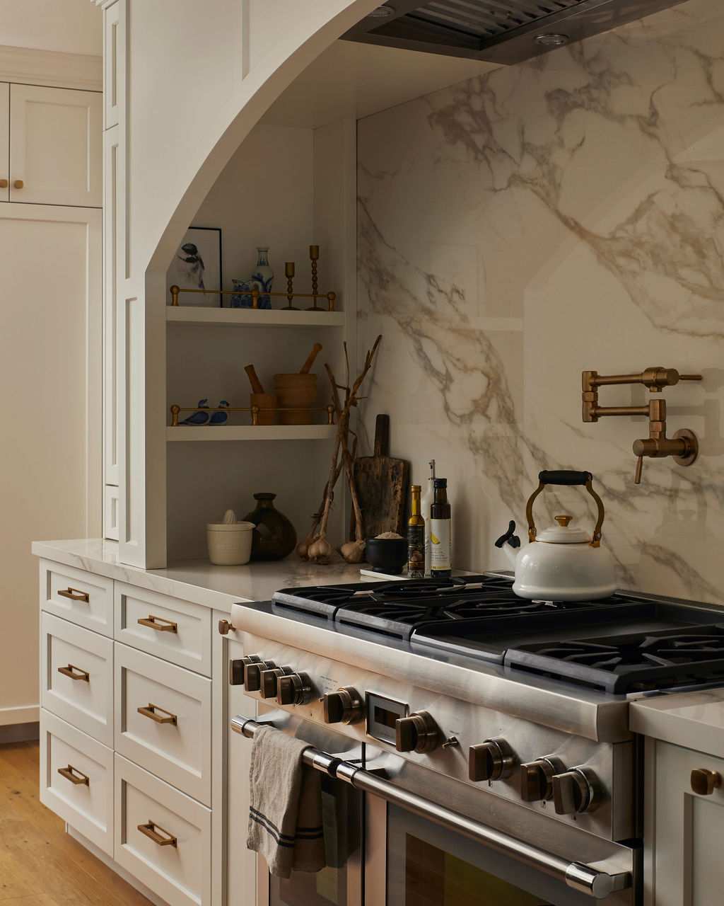 Stove area in custom white kitchen with porcelain backsplash