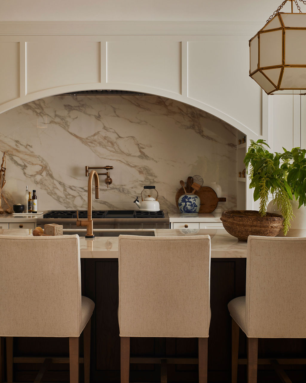 Custom white kitchen with gold hardware, large island, and porcelain countertops by Staci Edwards Design