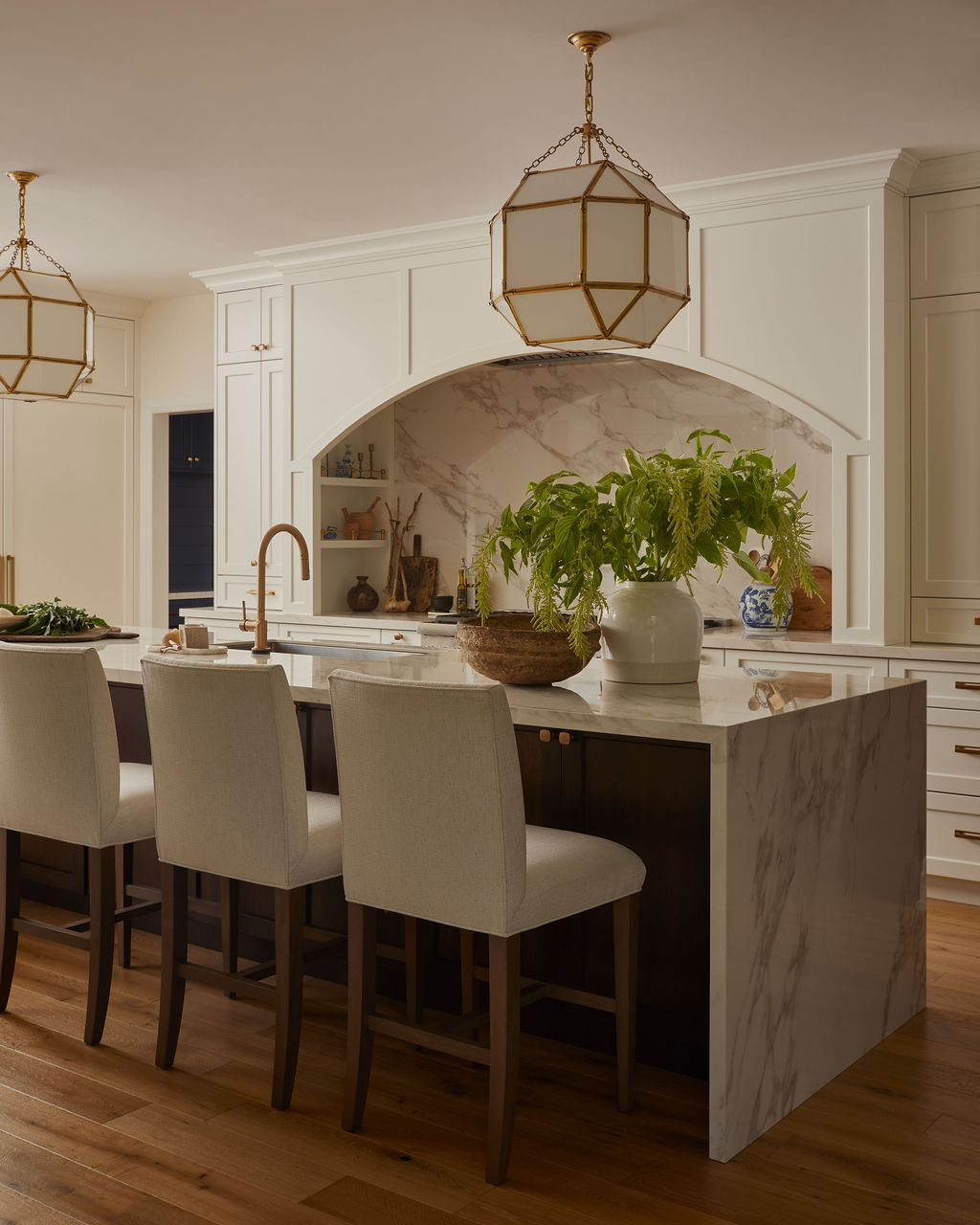 Custom white kitchen with gold hardware, large island, and porcelain countertops by Staci Edwards Design