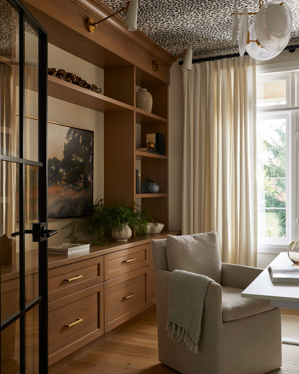 Elegant home office with leopard print wallpaper and warm, timeless design details