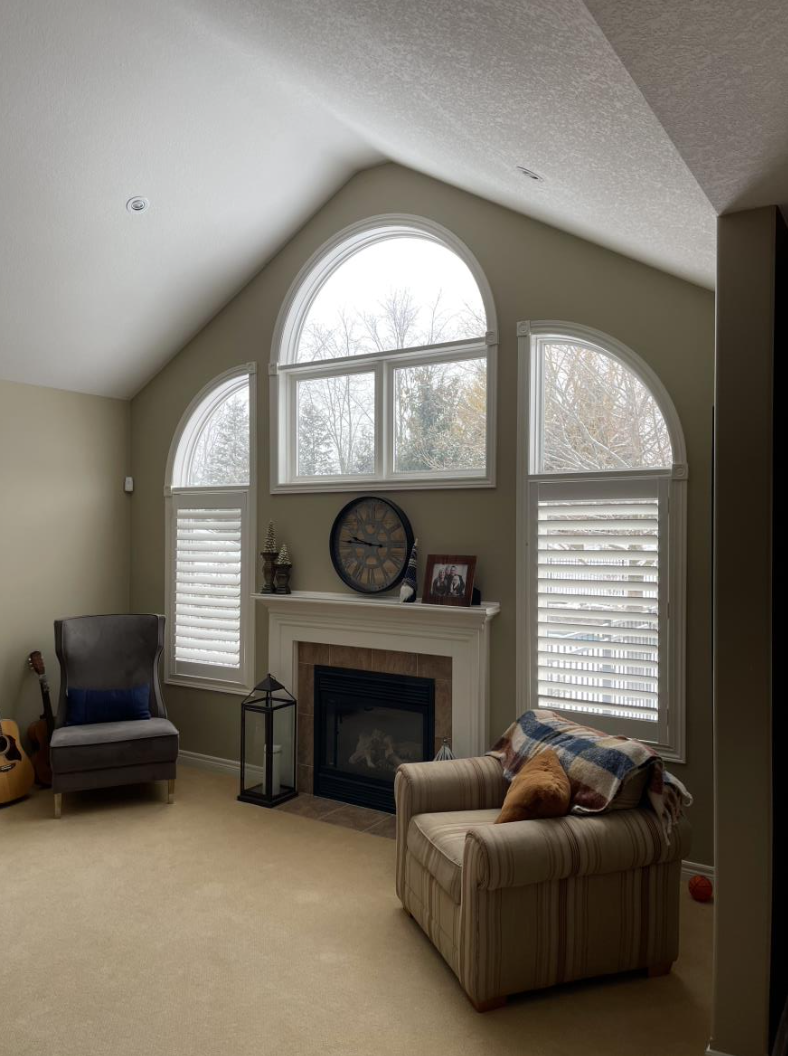 Before photo of the living room with original small fireplace and curved windows